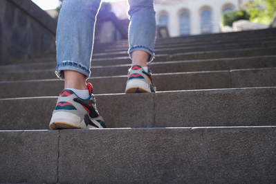 close up of female wearing sneakers walking up stairs