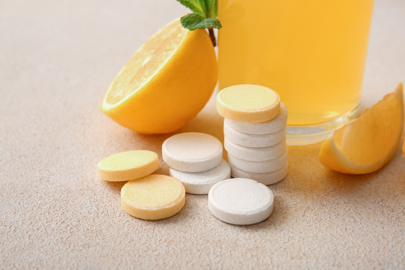 vitamin C chewables next to orange juice and orange slices