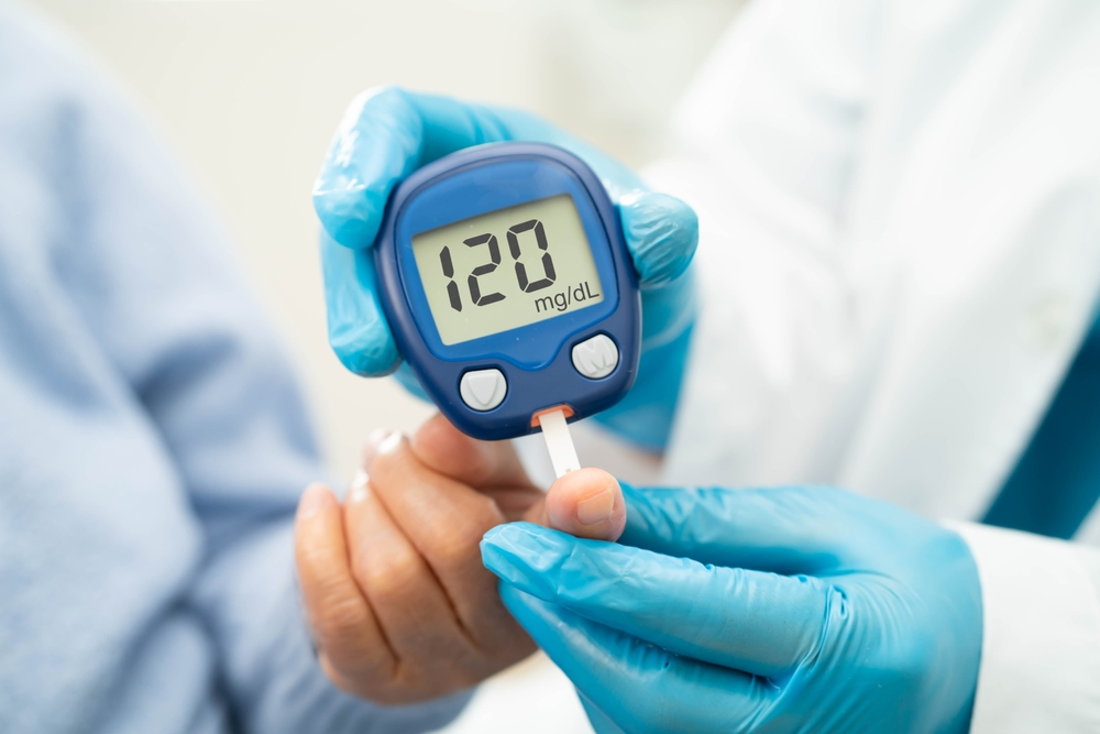 blood sugar test device showing 120 mg/dL